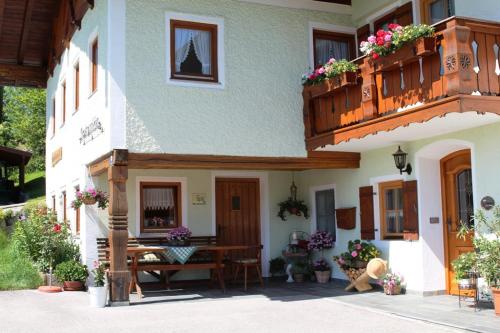 een huis met een tafel en een balkon bij Ferienwohnung Grasmannlehen in Marktschellenberg