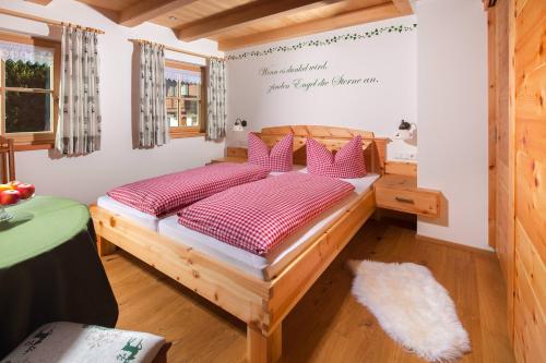 a bedroom with a wooden bed with pink pillows at Ferienwohnung Grasmannlehen in Marktschellenberg