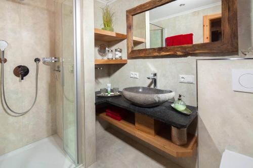 La salle de bains est pourvue d'un lavabo et d'une douche. dans l'établissement Ferienwohnung Grasmannlehen, à Marktschellenberg