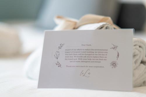 a piece of paper on a bed with a note at La Lu cozy rooms 2 in Pisa