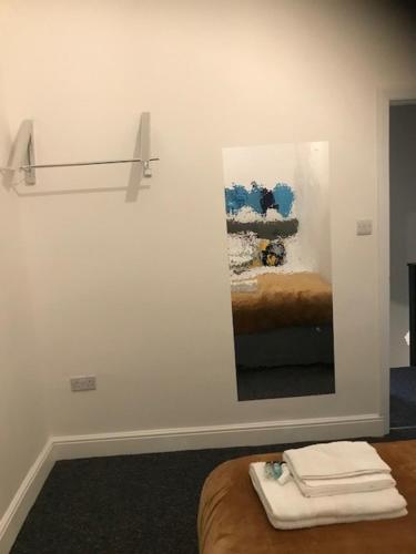 Cette chambre comprend un lit et un miroir mural. dans l'établissement Modern Comfort House On Eamont RD, à Stockton-on-Tees
