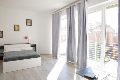 Un dormitorio con una cama y una ventana grande. en Casa Cesano Mare, en Senigallia
