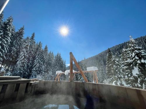 a person standing in a hot tub in the snow at Fantázia Kulcsosház in Ciumani