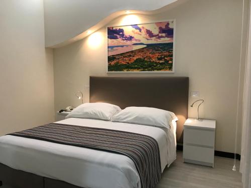 a bedroom with a large bed and a painting on the wall at Hotel River Palace in Terracina