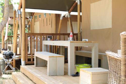 a table and benches sitting on a wooden deck at Glamping Florence in Troghi