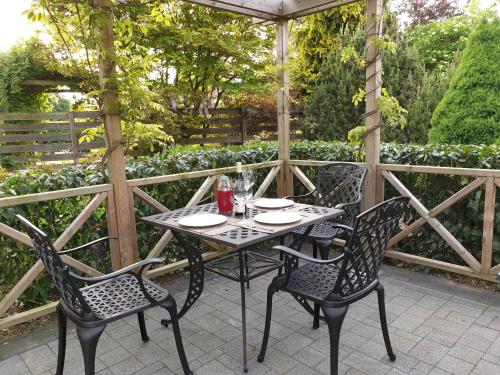 a table and chairs sitting on a patio with an umbrella at B&B Secret Garden in Voeren