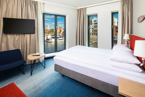 a hotel room with a large bed and a window at Holiday Inn Gdansk - City Centre by IHG in Gdańsk