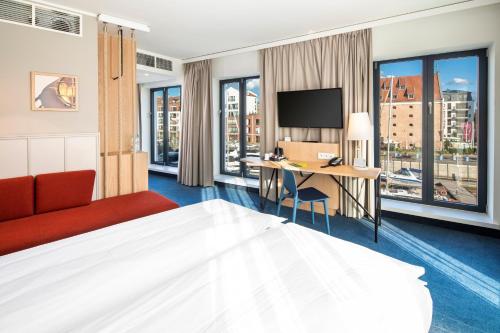 a hotel room with a bed and a desk at Holiday Inn Gdansk - City Centre by IHG in Gdańsk