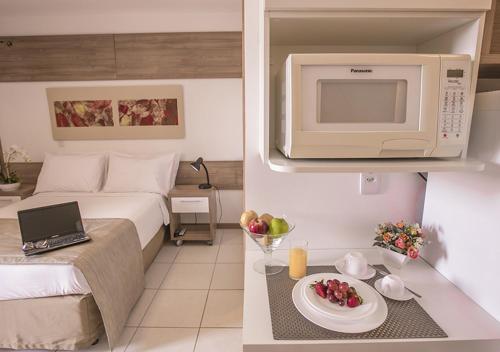 a kitchen with a microwave and a dishwasher at Life Resort Hplus Long Stay in Brasília