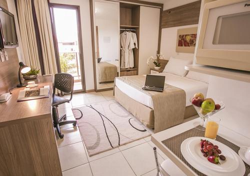 ein Hotelzimmer mit einem Bett und einem Tisch mit einem Obstteller in der Unterkunft Life Resort Hplus Long Stay in Brasilia