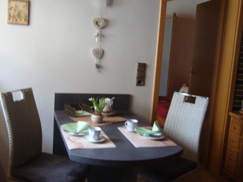 a dining table with two chairs and a table with at Eifelferienwohnungen "Familie Saxler" in Bereborn