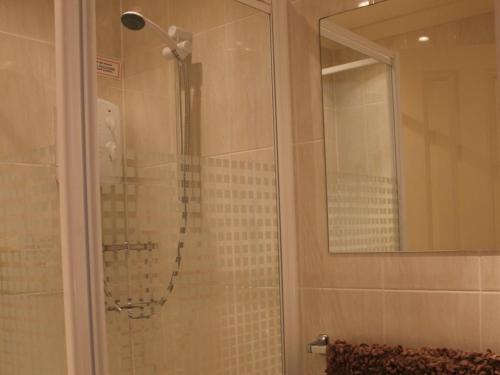 a shower with a glass door in a bathroom at Seagull Hotel in Blackpool