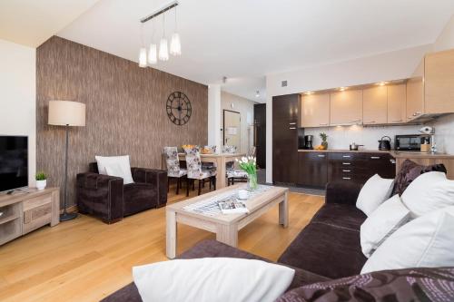 a living room with a couch and a table at Stara Polana Apartamenty & Spa Zakopane by Noclegi Renters in Zakopane
