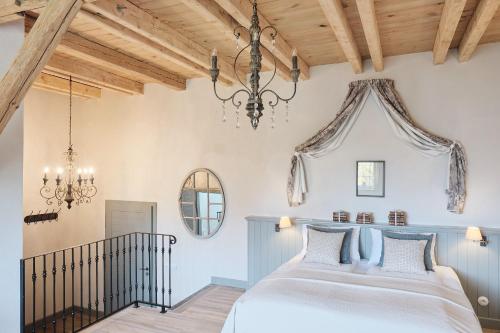 a bedroom with a bed and a chandelier at Pałac Kamieniec in Polanica-Zdrój