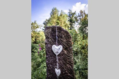 a stone statue with a heart necklace on it at ENJOY Cozy HOME Hills & Forest & Views & Gardens & Sauna Whirlpool Bath in Jablonné v Podještědí
