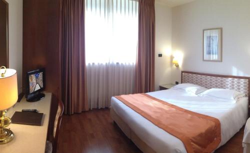 a hotel room with a bed and a large window at Hotel Marconi in Padova