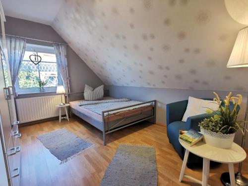 - une chambre avec un lit, un canapé et une fenêtre dans l'établissement Ferienhaus Scharhörn, à Horumersiel