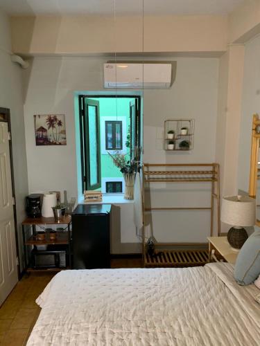 a bedroom with a bed and a desk and a window at The Bambu Room at Casa of Essence located in heart of Old San Juan in San Juan