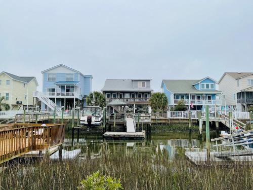 a group of houses on the water with a marina at Beach Bells Home in Holden Beach