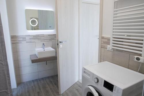 Un baño con lavabo y lavadora. en Casa Cesano Mare, en Senigallia