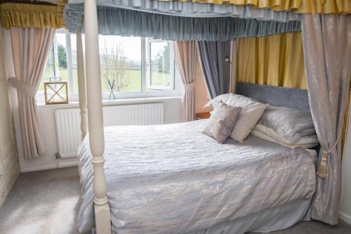 a bedroom with a canopy bed and a window at The Cottage Tea Room B&B in Kettlewell