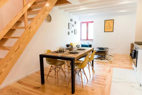 a dining room with a black table and yellow chairs at Porto Wine Loft Duplex with swimming pool in Vila Nova de Gaia