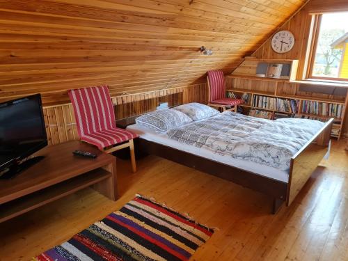 a bedroom with a bed and two chairs and a tv at Paide Homestay in Kriilevälja