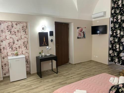 a bedroom with a bed and a table and a television at The house Porta Garibaldi in Catania