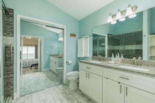 a blue bathroom with a toilet and a sink at On Galveston Bay Spacious Home with Pier and Grills! in San Leon