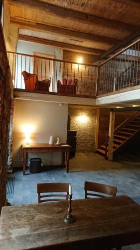 Pension Müllers Mühle في وغروسنهاين: غرفة مع طاولة وكراسي ودور علوي