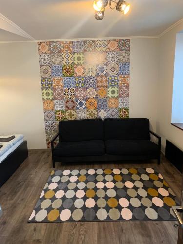 a living room with a couch and a tile wall at Filkes Rezidence in Filkeháza