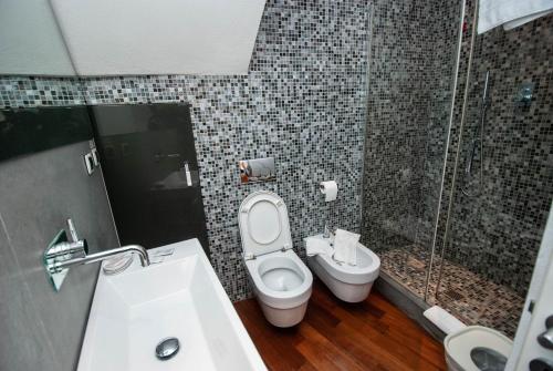 a bathroom with a toilet and a sink and a shower at Luxury Seaview Apartments Manarola by Arbaspàa in Manarola