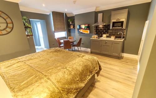 a bedroom with a large bed and a kitchen at The Hotel Chester in Chester