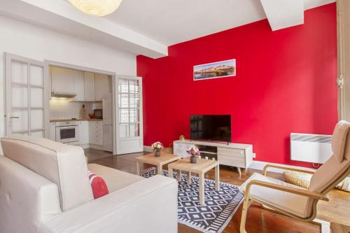 a living room with a red wall at Flat in the historic heart 2min to the river - Bayonne - Welkeys in Bayonne