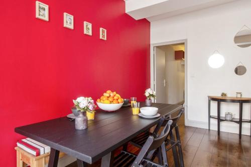une salle à manger avec un mur rouge dans l'établissement Flat in the historic heart 2min to the river - Bayonne - Welkeys, à Bayonne