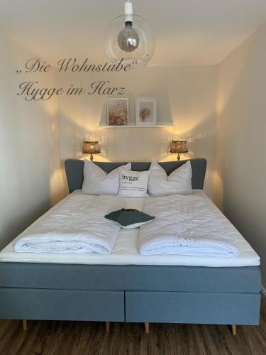 a bed in a bedroom with a sign on the wall at "Die Wohnstube"-Hygge im Harz in Wernigerode