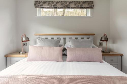 
a bed with a white comforter and pillows at The Gamekeeper's Inn in Skipton
