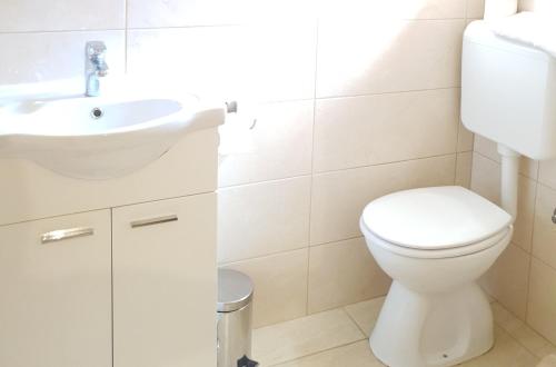 a white bathroom with a toilet and a sink at DELIA in Međugorje