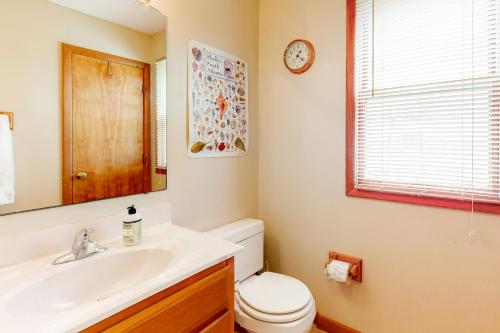 a bathroom with a toilet and a sink and a clock at Red Rover #19-F in Frisco