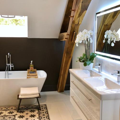une salle de bain avec une baignoire blanche et un lavabo dans l'établissement Manoir de La Croix Saint Louis 