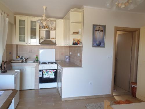 a kitchen with white cabinets and a white stove top oven at DELIA in Međugorje