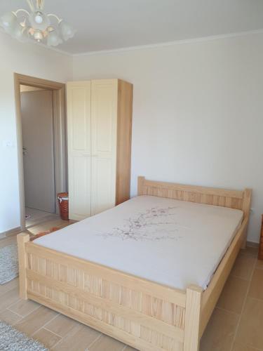 a bedroom with a wooden bed in a room at DELIA in Međugorje