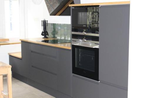 Il comprend une cuisine équipée d'une cuisinière et d'un évier. dans l'établissement Maison de charme en plein centre ville, à Montreuil-sur-Mer