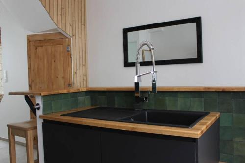 uma cozinha com um lavatório e um espelho em Maison de charme en plein centre ville em Montreuil-sur-Mer