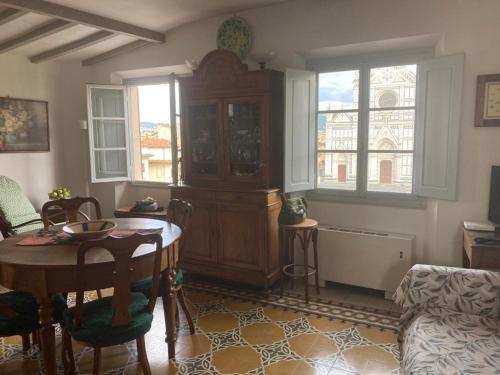 a living room with a table and a large wooden cabinet at ATTICO IN PIAZZA SANTA CROCE in Florence