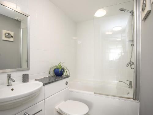 een witte badkamer met een wastafel en een toilet bij Twyni Bach in Rhosneigr