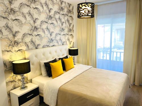 1 dormitorio con cama blanca y almohadas amarillas en Palacio Apartments Madrid en Madrid