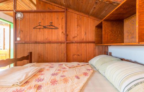 a bedroom with a bed in a wooden wall at House Tvrdica in Tkon