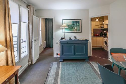 un salon avec une armoire bleue et une cuisine dans l'établissement Appartement de la Tour - Welkeys, à Paris