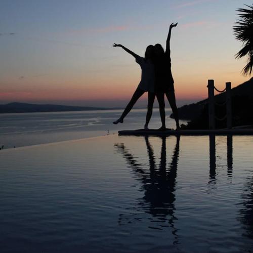 a woman standing on the beach with her arms in the air at 5 stars 2 bedrooms villa BLUE DREAM village Pisak Croatia in Pisak